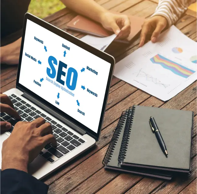 person on computer with documents referencing search engine optimization