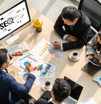 team of men working around desk and computer display showing seo