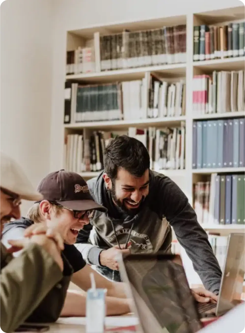 team standing behind laptop and pointing to it